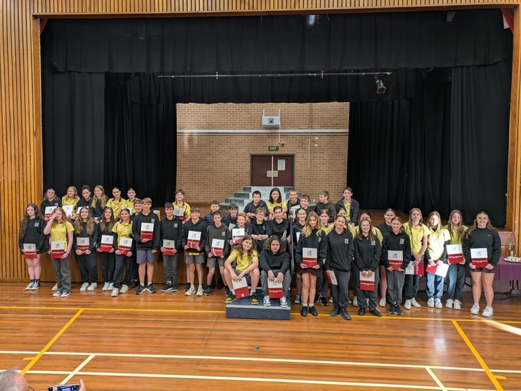 Group of students with certificates at Recognition of Student Excellence breakfast in school hall