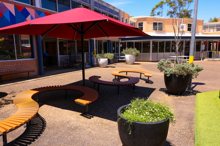 A group of benches and umbrellas in a courtyard
