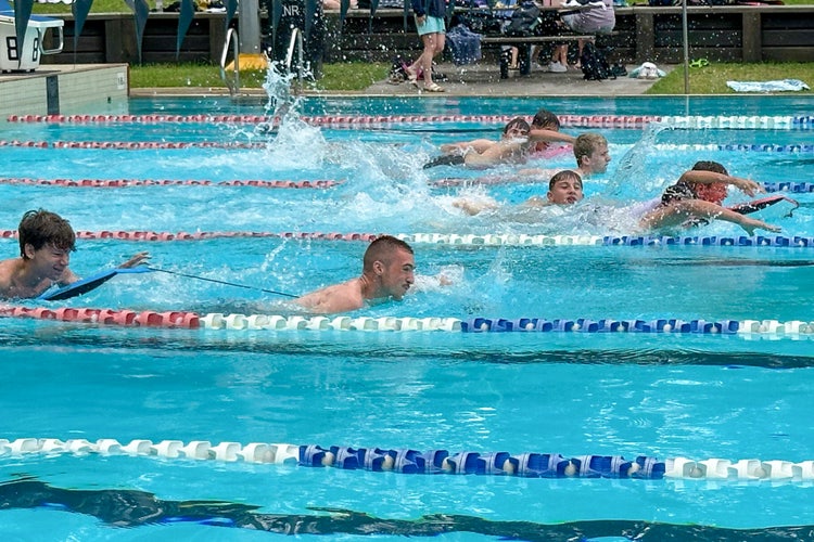 Swimmers in pool lanes at school swimming carnival