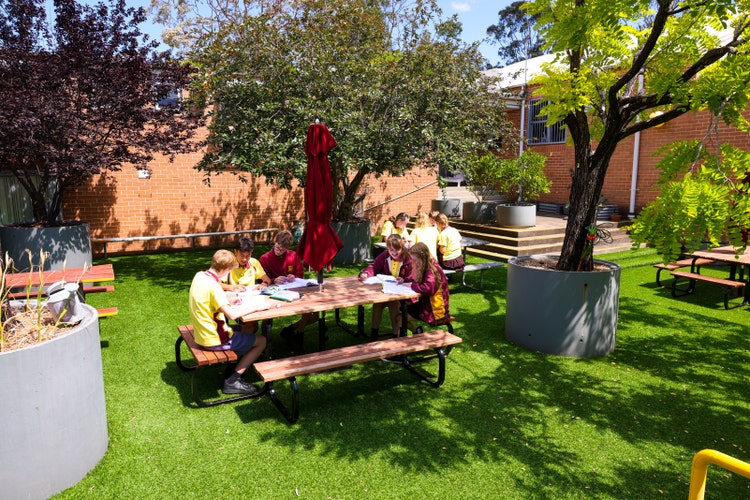 Students working at table outdoors in science courtyard