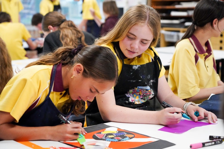 A group of girls painting on paper