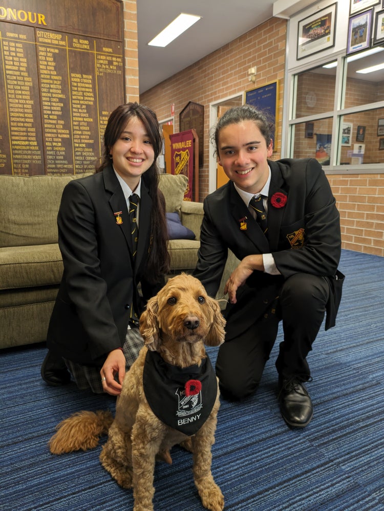 A person and person in school uniforms with a dog